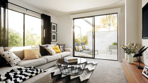 A lounge room setting, showing a couch and aluminium sliding doors